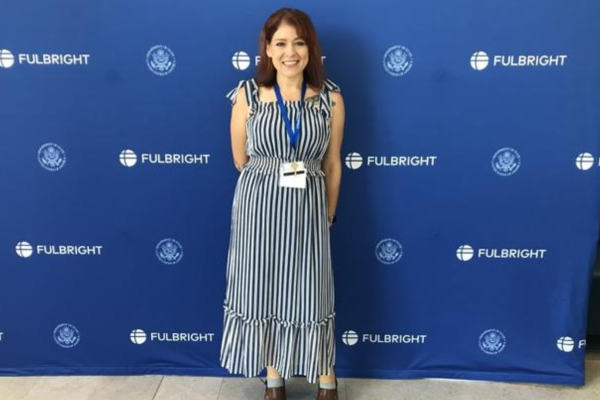 photo of Elizabeth Avery in front of blue background with Fulbright logo