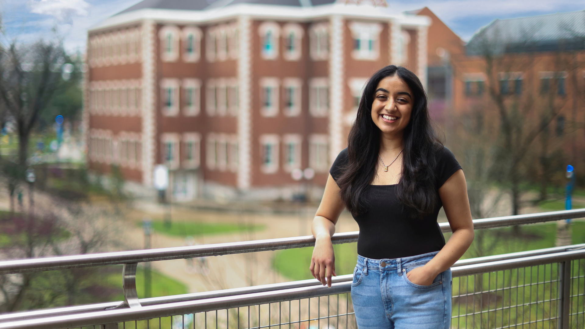 Isha Chauhan on balcony in front of Miller Hall