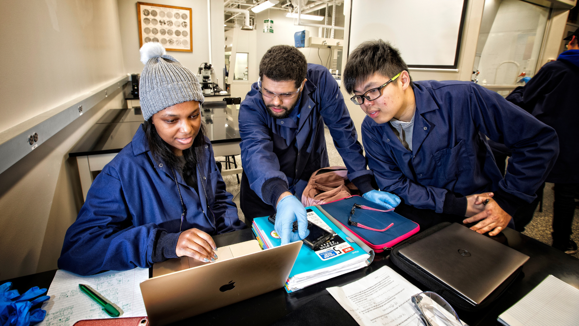 Three students looking at laptop 