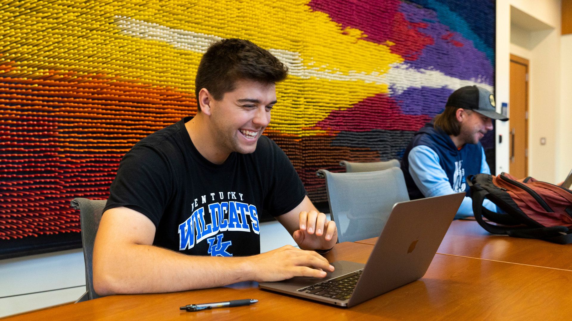 student laughing and looking at laptop on table