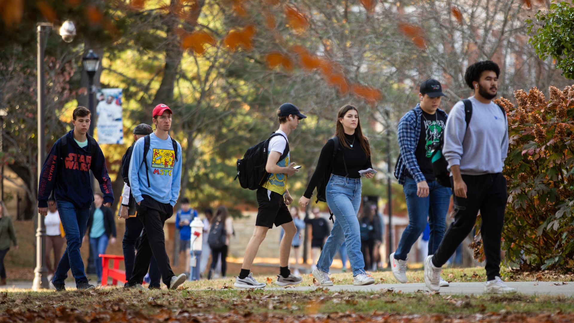 Group of student walking across campus in the fall