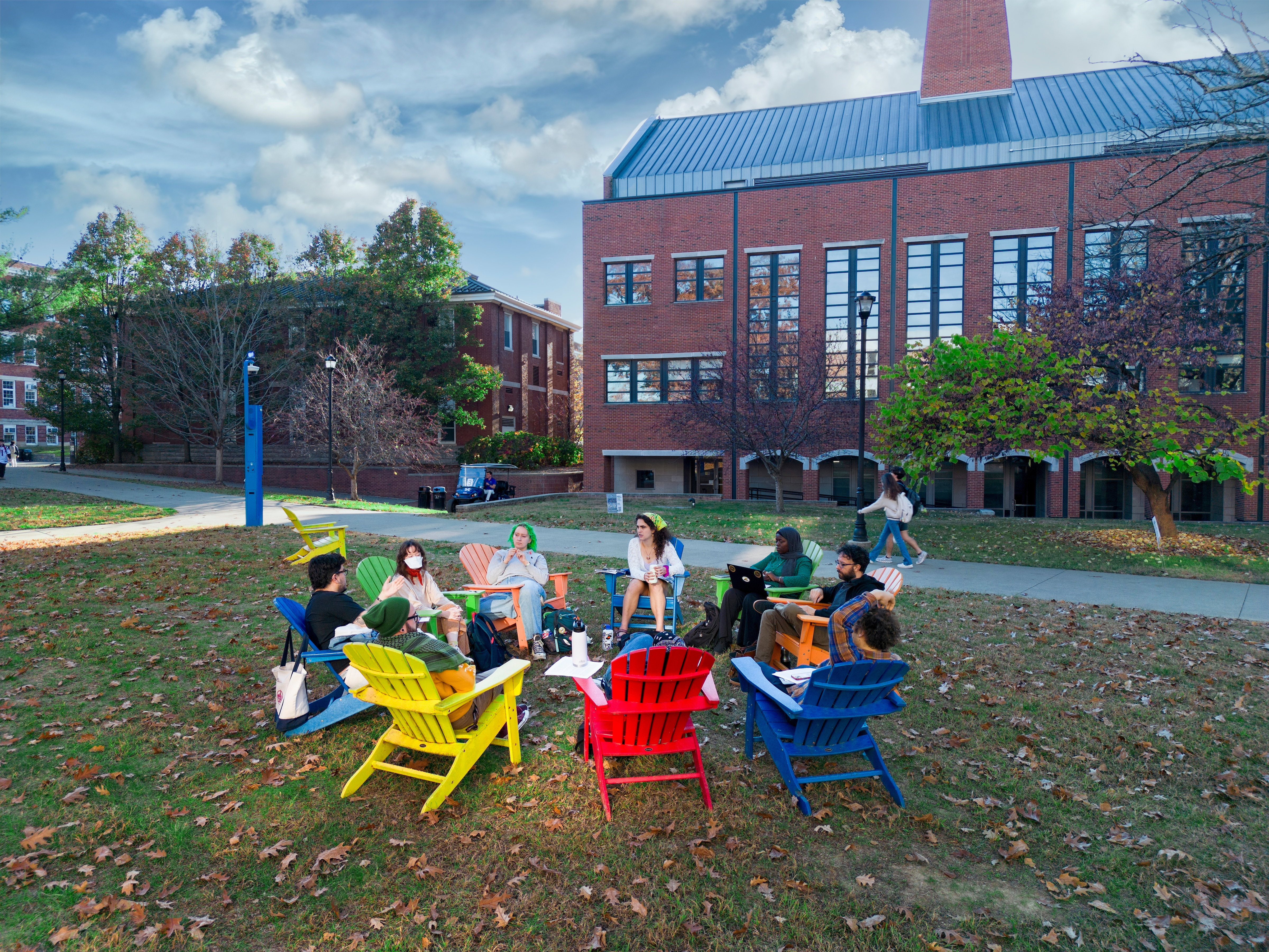 Students sitting in a circle in Adirondack chairs outside