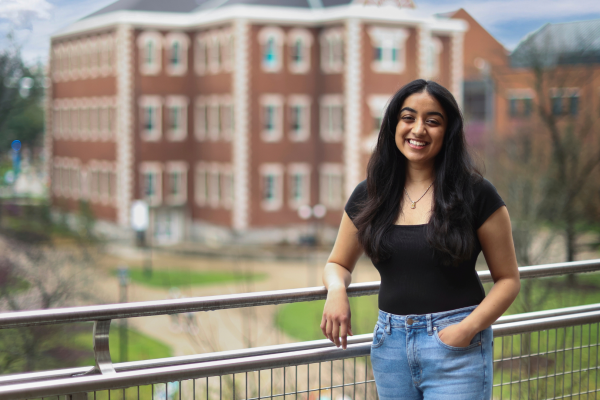 Isha Chauhan on balcony in front of Miller Hall
