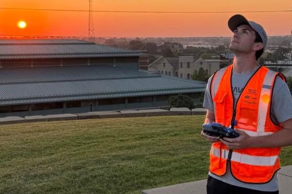 Asa O'Neal looks up to the sky while piloting a drone