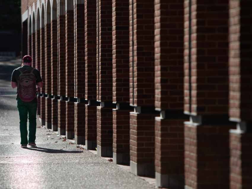 Man walking beside brick building