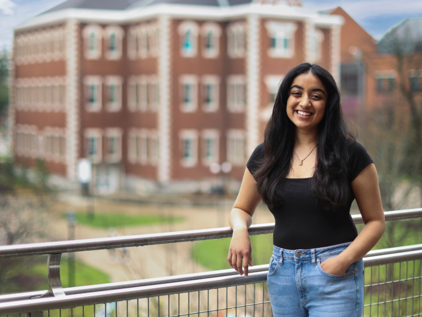 Isha Chauhan on balcony in front of Miller Hall