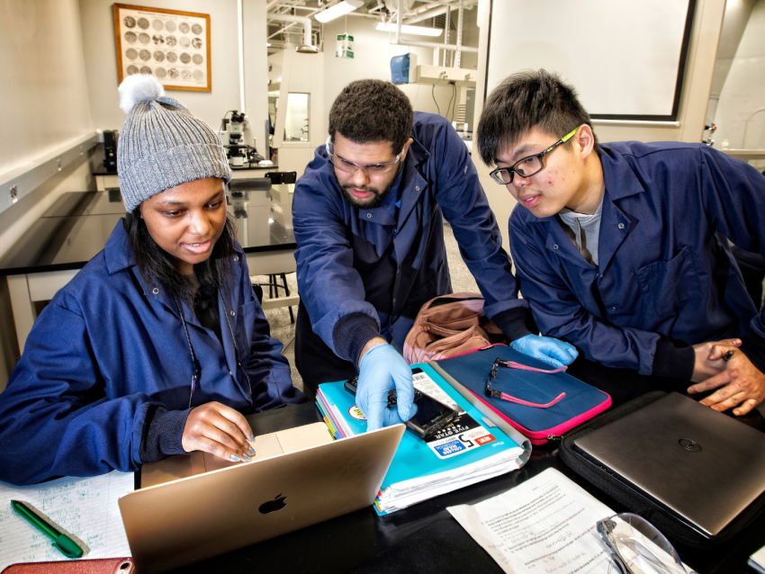 Three students looking at laptop