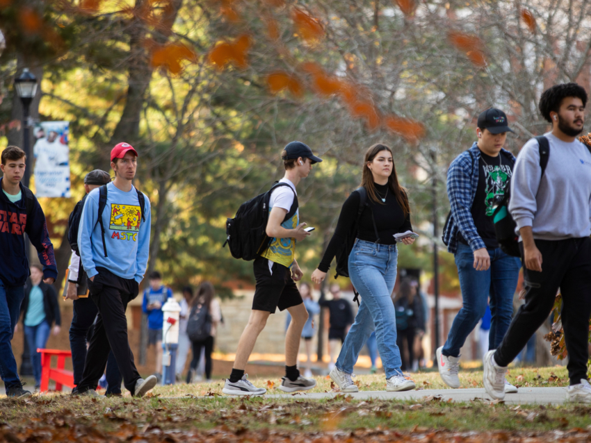 Group of student walking across campus in the fall