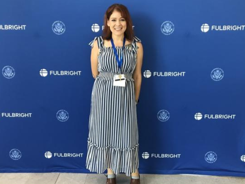 photo of Elizabeth Avery in front of blue background with Fulbright logo