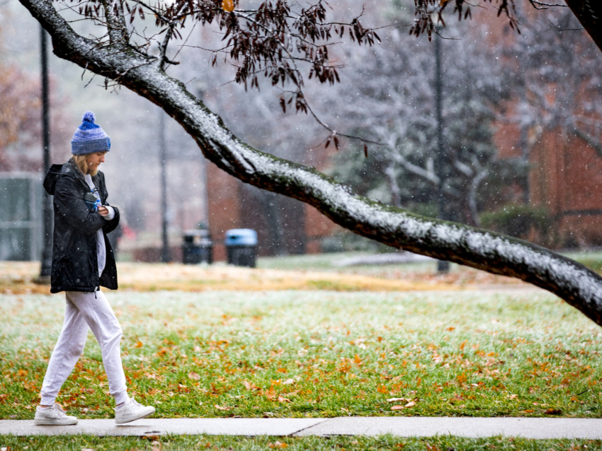student walking across campus in the snow