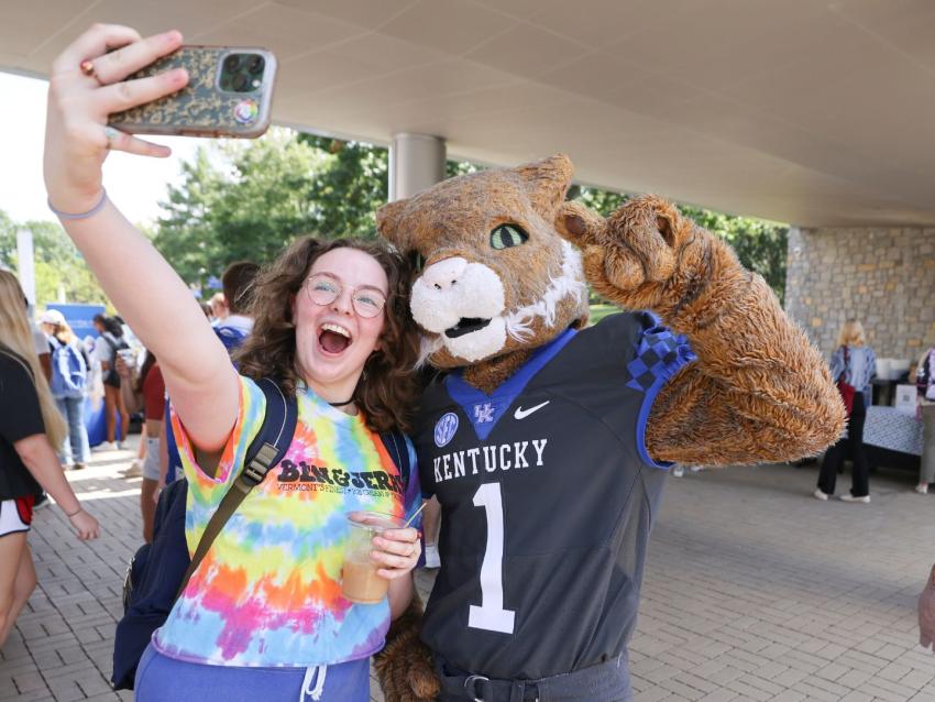 student talking a photo with her phone of her and Wildcat
