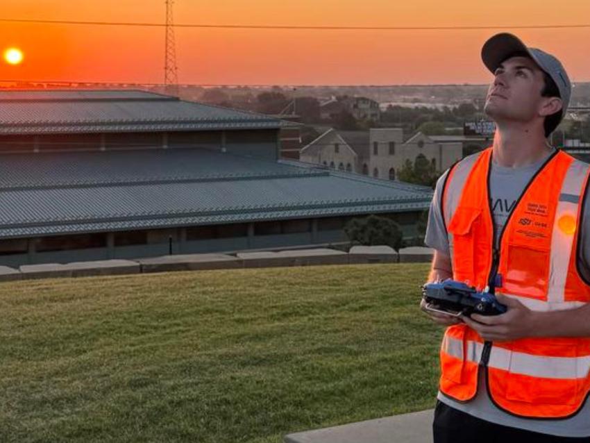 Asa O'Neal looks up to the sky while piloting a drone