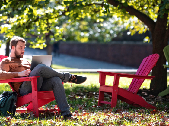 Student studying outside in chair