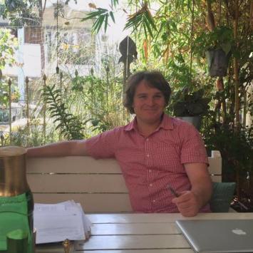 Daniel Ball sitting at table with trees in background