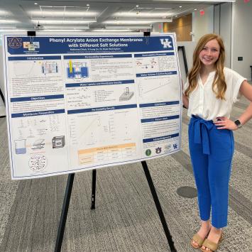 McKenna Clinch standing next to research poster