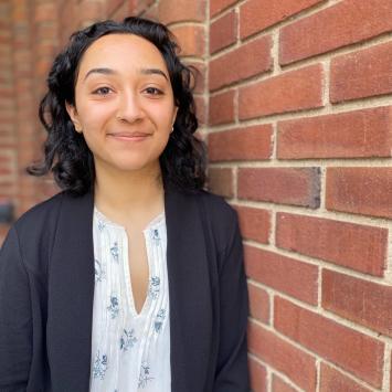 Hena Kachroo standing near a brick wall