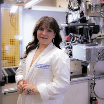 Jenna Money standing in laboratory in white coat